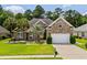 Charming brick home featuring a manicured lawn, palm trees, and a two-car garage at 950 Henry James Dr., Myrtle Beach, SC 29579