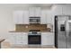 This is a kitchen view of the white cabinetry, stainless appliances and a mosaic tile backsplash at 950 Henry James Dr., Myrtle Beach, SC 29579