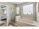 The main bathroom features a glass enclosed shower, garden tub and decorative window at 950 Henry James Dr., Myrtle Beach, SC 29579
