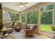 This is a view of the screened-in porch with wicker chairs, ceiling fan and views of the backyard at 950 Henry James Dr., Myrtle Beach, SC 29579