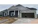 New home under construction featuring a two-car garage and covered entry at 977 Oak Hollow St., Longs, SC 29568