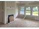 Living room with fireplace and large windows overlooking the backyard at 977 Oak Hollow St., Longs, SC 29568