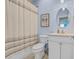 Well-lit bathroom with a shower/tub combo, white vanity, toilet, and light blue walls at 1012 Mary Read Dr., North Myrtle Beach, SC 29582