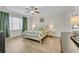 Bright bedroom featuring wood floor, queen-sized bed, ceiling fan, and abundant natural light at 1012 Mary Read Dr., North Myrtle Beach, SC 29582