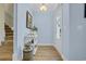 Inviting entryway with light blue walls, decorative table, and access to the staircase and front door at 1012 Mary Read Dr., North Myrtle Beach, SC 29582
