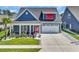 Charming blue home featuring a two-car garage, front lawn, tasteful landscaping, and a covered front porch at 1012 Mary Read Dr., North Myrtle Beach, SC 29582