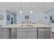 Kitchen island featuring a stainless steel sink, a white countertop, and gray cabinets at 1012 Mary Read Dr., North Myrtle Beach, SC 29582