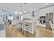 Bright, modern kitchen with white cabinetry, stainless steel appliances, an island with seating, and hardwood floors at 1012 Mary Read Dr., North Myrtle Beach, SC 29582