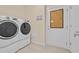 Bright laundry room featuring modern washer and dryer, beige walls and ceramic tile flooring at 1012 Mary Read Dr., North Myrtle Beach, SC 29582