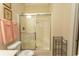Bright bathroom featuring a shower with sliding glass doors and convenient storage shelving at 1028 Fairway Ln. # 71, Conway, SC 29526