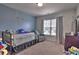Charming bedroom featuring a light blue accent wall, soft carpet, and a window for natural light at 1029 Tee Shot Dr. # 1029, Conway, SC 29526