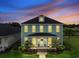 Stunning two-story home with a welcoming front porch, a well-kept lawn, and beautiful evening lighting at 1106 Tarpon Pond Rd., North Myrtle Beach, SC 29582