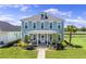 Charming two-story home with a welcoming front porch, well-manicured lawn, and beautiful landscaping at 1106 Tarpon Pond Rd., North Myrtle Beach, SC 29582