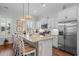 Bright kitchen with white cabinetry, stainless steel appliances, a granite island, and stylish pendant lighting at 1106 Tarpon Pond Rd., North Myrtle Beach, SC 29582