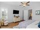 Bright main bedroom with wood floors, mounted television, soft furnishings, and ensuite bathroom at 1106 Tarpon Pond Rd., North Myrtle Beach, SC 29582