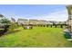 Large, grassy backyard showcasing outdoor seating, landscaping, and black metal fence at 1189 Wyatt Ln., Myrtle Beach, SC 29577