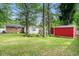 A large backyard with a red shed, privacy fence, and view of the home at 1205 King St., Myrtle Beach, SC 29577