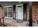 Front door of brick home featuring black shutters, a glass door, and plants at 1205 King St., Myrtle Beach, SC 29577