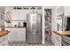 The kitchen features a stainless steel refrigerator, decorative tile flooring, butcher block counters, and white cabinetry at 1209 Eagle Creek Dr., Myrtle Beach, SC 29588