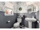 The powder room features a unique pedestal sink, decorative wallpaper, a large window, and beadboard accents at 1209 Eagle Creek Dr., Myrtle Beach, SC 29588