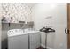 Bright laundry room with modern appliances, shelving, and decorative wallpaper at 142 Grier Crossing Dr., Conway, SC 29526