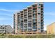 Multi-story condo building featuring private balconies, offering stunning views of the surrounding landscape and blue sky at 1501 Ocean Blvd. S # 103, North Myrtle Beach, SC 29582