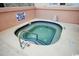Inviting hot tub with blue tile trim and a stainless steel handrail offers relaxation in a cozy setting at 1501 Ocean Blvd. S # 103, North Myrtle Beach, SC 29582