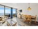 Open-concept living and dining area with ocean views, balcony access, and beach-inspired decor at 1501 Ocean Blvd. S # 103, North Myrtle Beach, SC 29582