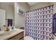 Bathroom with a single sink, vanity, toilet, and shower with patterned curtain at 176 Springtide Dr., Conway, SC 29527