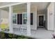 Inviting covered front porch with white rocking chairs, black shutters, and a welcoming wreath on the front door at 179 Empyrean Circle, Myrtle Beach, SC 29588