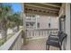Balcony showcasing a pair of black chairs and the building next to many palm trees at 1801 N Ocean Blvd. # Q-2, North Myrtle Beach, SC 29582