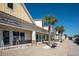 Retail shops along a sidewalk featuring store fronts, benches and palm trees on a sunny day at 1801 N Ocean Blvd. # Q-2, North Myrtle Beach, SC 29582
