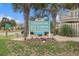 A sign that says 'Tilghman Lakes by the Sea' surrounded by palm trees and flowers at 1801 N Ocean Blvd. # Q-2, North Myrtle Beach, SC 29582
