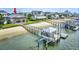 Aerial view of a waterfront home featuring a pier, beach access, and beautiful landscaping at 1924 Pompano Dr., Garden City Beach, SC 29576