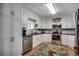 A bright kitchen featuring stainless steel appliances, tile backsplash, and white cabinetry at 1924 Pompano Dr., Garden City Beach, SC 29576