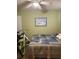 Bedroom featuring green walls, a ceiling fan, and a beach themed painting above a bed at 2005 Greens Blvd. # F-205, Myrtle Beach, SC 29577