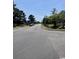 View of a street with overhead trees and a grassy median in a residential area at 2005 Greens Blvd. # F-205, Myrtle Beach, SC 29577