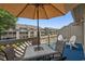 Outdoor seating on balcony with shade umbrella and views of the landscaped community and pool at 202 Maison Dr. # L-301, Myrtle Beach, SC 29572