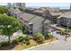 An exterior view of a condo featuring multiple balconies, a stairwell, mature landscaping, and on-site parking at 202 Maison Dr. # L-301, Myrtle Beach, SC 29572