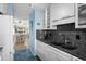 Galley kitchen featuring tile floors, granite counters and white cabinetry at 202 Maison Dr. # L-301, Myrtle Beach, SC 29572