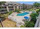 Aerial view of a community swimming pool with lounge chairs and mature landscaping and condos in the background at 202 Maison Dr. # L-301, Myrtle Beach, SC 29572