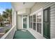 Charming balcony featuring green painted flooring, white trim and a glimpse of tropical palm trees at 212 Millwood Dr., Surfside Beach, SC 29575