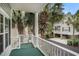 Relaxing balcony view with white railing and columns, surrounded by tropical palm trees and lush greenery at 212 Millwood Dr., Surfside Beach, SC 29575