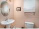 Bathroom features a pedestal sink, toilet, framed artwork, and window with blinds at 212 Millwood Dr., Surfside Beach, SC 29575
