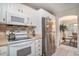 Kitchen features stainless steel refrigerator, white cabinetry, and adjacent dining area at 212 Millwood Dr., Surfside Beach, SC 29575