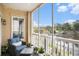 Cozy balcony with wicker chair and a view of the river, foliage, and distant residential homes at 2180 Waterview Dr. # 725, North Myrtle Beach, SC 29582