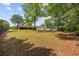 Expansive backyard with lawn and mature trees provides a serene outdoor setting with ample space for recreation at 219 Caropine Dr., Surfside Beach, SC 29575