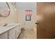 Vintage bathroom with floral wallpaper, decorative mirror, and a window with a pink valance allowing for natural light at 219 Caropine Dr., Surfside Beach, SC 29575