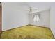 Simple bedroom with green carpet, white walls, ceiling fan and window featuring a decorative curtain, ready for personalization at 219 Caropine Dr., Surfside Beach, SC 29575