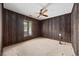 Bedroom featuring wood panel walls, a ceiling fan and a window with mini blinds at 219 Caropine Dr., Surfside Beach, SC 29575